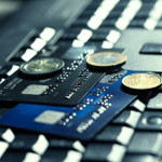 Kreditkarten und Münzen liegen auf Tastatur